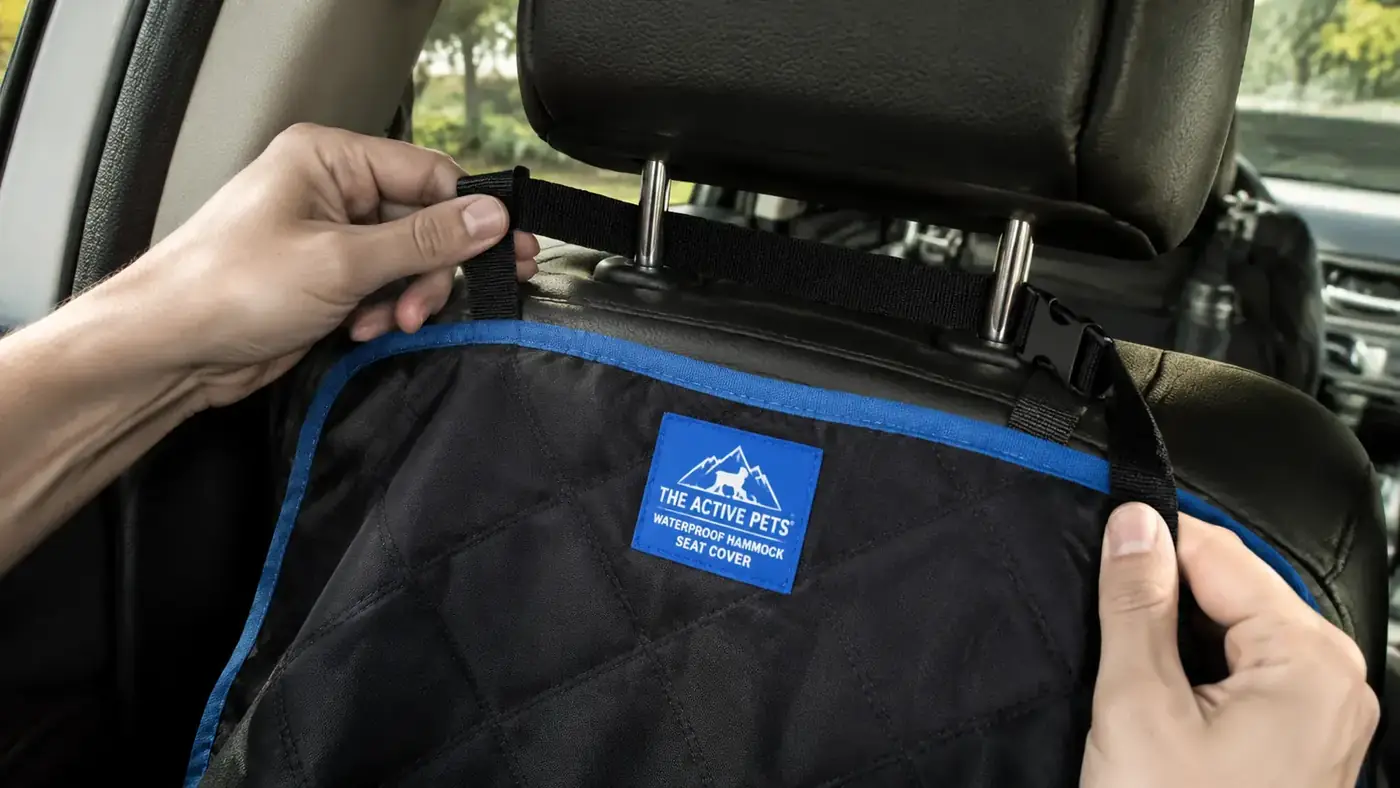 Close-up of the headrest anchor straps on an Active Pets hammock seat cover showing the strap hardware looped around a car headrest
